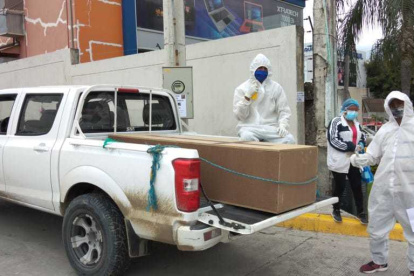 Un par de ayudantes de Édison Zúñiga suele colocar los féretros en su camioneta.