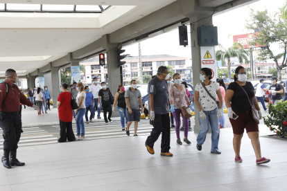 Un grupo de personas hacen fila para ingresar a bancos y a un supermercado.