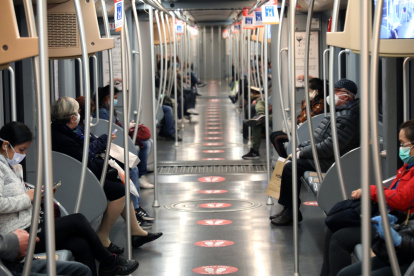 MILÁN. (Italy), 27/04/2020.- People wearing face masks respect social distancing measures while seated inside a subway carriage in Milan, northern Italy, 27 April 2020, during the coronavirus disease (COVID-19) pandemic. (Italia) EFE/EPA/