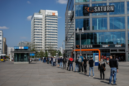 People wait in line to enter an electronics store at Berlin"s Alexanderplatz on April 27, 2020, amid the novel coronavirus COVID-19 pandemic. (Photo by David GANNON / AFP)