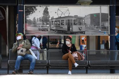 BERLÍN. Varias personas esperan un bus urbano en un barrios de esta capital europea, que desde hoy miércoles ordena el uso de mascarillas.