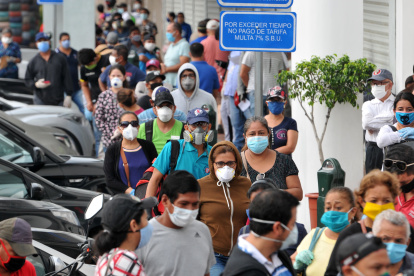 People wear face masks as they wait in line outside a bank in Guayaquil on April 28, 2020, amid the new coronavirus pandemic. - Ecuador reported 24,258 cases of COVID-19 so far, including 871 deaths, plus 1,212 other deaths of people who were suspectedly infected. (Photo by JOSE SANCHEZ LINDAO / AFP)
