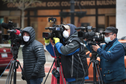 CHICAGO, ILLINOIS - APRIL 30: Journalist wearing masks document a protest where demonstrators were calling on the governor to suspend rent and mortgage payments to help those who have lost their income due to the coronavirus on April 30, 2020 in Chicago, Illinois. On May 1, the state of Illinois will begin requiring everyone to wear a face mask in public when social distancing is not possible to prevent the spread of the coronavirus COVID-19. The state is currently on a "stay at home" mandated by the governor until May 30.   Scott Olson/Getty Images/AFP