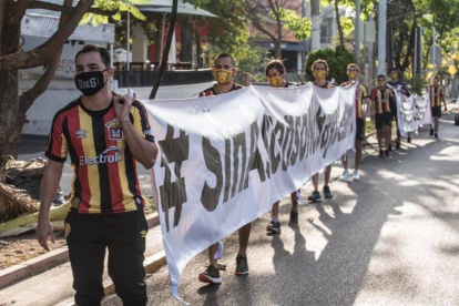 Los jugadores de Leones Negros protestan con mascarillas por el coronavirus.