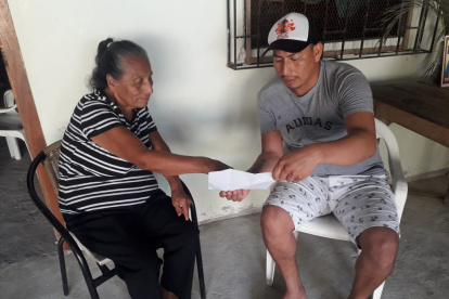 Manuela Pilay muestra la partida de defunción a un familiar. No sabe cómo se registró ”su muerte” en otra provincia, por alguien que su familia no conoce.