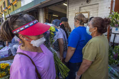 LOS ANGELES, CA - MAY 08: People mingle close to one another as businesses in the flower district in Skid Row reopen in time for Mothers Day on May 8, 2020 in Los Angeles, California. Local stay-at-home restrictions are being relaxed to allow the reopening of some businesses, including bookshops, clothing stores, car dealerships, and some low-risk retailers that can provide curbside pickup. Many recreational areas like parks, trails and golf courses are set to reopen tomorrow as well. However, L.A. mayor Eric Garcetti has repeatedly warned that if people do not wear masks or face coverings and practice social distancing at these businesses and locales, the city may have to close them down once again.   David McNew/Getty Images/AFP