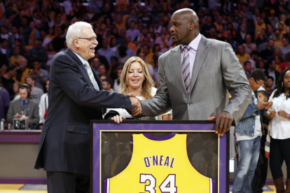Shaquille O"Neal (d)en una de sus últimas apariciones cuando recibió de manos del entrenador Phil Jackson la camiseta emblemática de los Lakers.