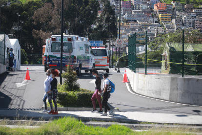 Un grupo de personas, protegidas con mascarillas, pasa frente al Hospital del IESS del Sur de Quito, este fin de semana.