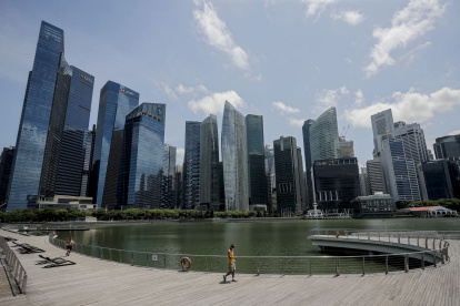 Singapore (Singapore), 05/05/2020.- A man wearing a protective face mask in front of the financial district along the Marina Bay in Singapore, 05 May 2020, amid the ongoing coronavirus COVID-19 pandemic. As the number of COVID-19 coronavirus cases in the local community fall, Singapore will start easing "circuit breaker" partial lockdown measures. Businesses such as traditional Chinese medical practitioners will be allowed to operate from today onwards and other home-based food businesses, barbers, laundry services and pet supply shops will open on 12 May 2020. (Abierto, Singapur, Singapur) EFE/EPA/WALLACE WOON