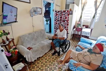 La pareja de sexagenarios Inés d y Egaldo observan en la televisión la habitual conferencia del Ministerio de Salud Pública este viernes, en La Habana (Cuba).