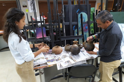 Enrique Palma Chenche selecciona junto a una estudiante las piezas de la casa comunal que servirán para el futuro museo.