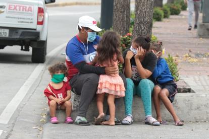 Riesgo. Un padre sale a las calles de Guayaquil con sus cuatro hijos, cuando el semáforo aún indica que se debe mantener el distanciamiento físico.