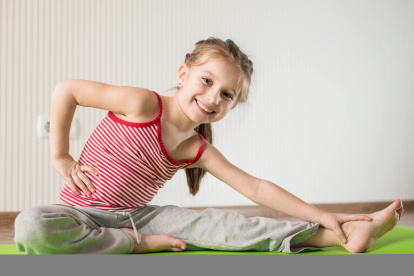 Niña realiza ejercicios e estiramientos.