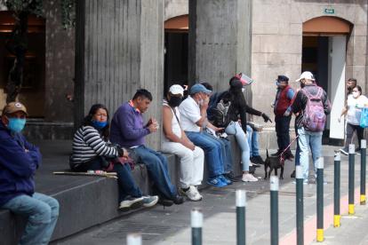 Ciudadanos en Quito usan medidas de seguridad como mascarillas al caminar por el Centro Histórico.
