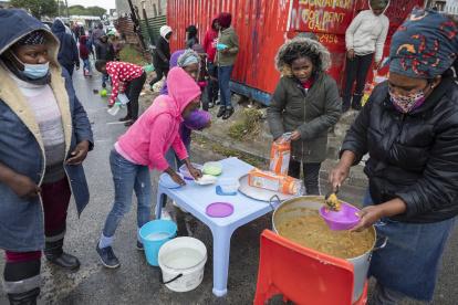 CIUDAD DEL CABO. Yandiswa Mazwana y otros ayudantes distribuyen alimentos del esquema de alimentación Masiphumelele Creative Hub dirigido por Yandiswa Mazwana en Masiphumelele,