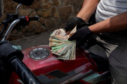 Panorama. Un motociclista necesita una buena cantidad de bolívares y dólares para poder cargar gasolina.