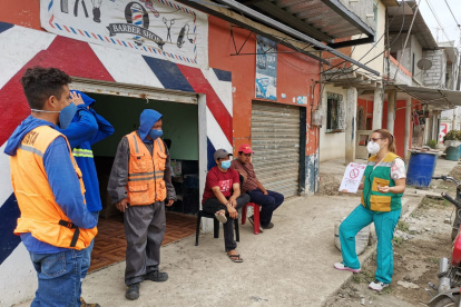 Un grupo de trabajadores escuchan las charlas del personal de salud.