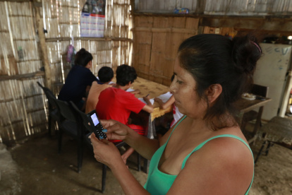 A través de un teléfono celular vetusto, esta madre trata de comunicarse con los maestros de sus hijos. En su casa no hay computador.