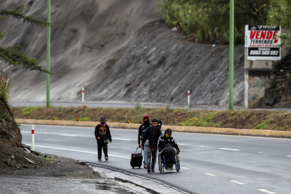Ciudadanos venezolanos, uno de ellos con discapacidad, transitan el pasado 28 de mayo en una carretera cercana a Quito.