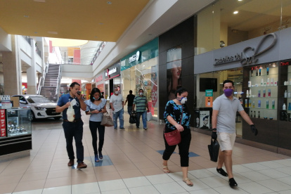 En un centro comercial de Guayaquil se observan a dos personas sin mascarilla.