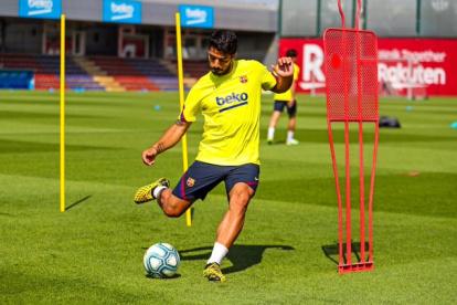 El delantero Luis Suárez entrena a la par de sus compañeros del Barcelona español.