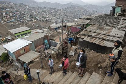 Un grupo de mujeres hacen cola para recibir algo de agua en el barrio Pamplona Alta, una de las zonas más pobres de Lima, capital de Perú.