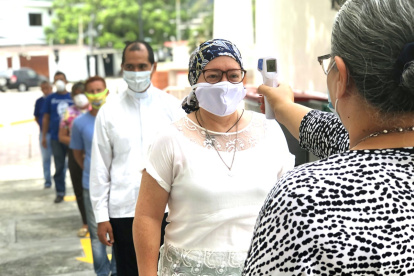 Salud. Los feligreses en columna esperan para cumplir el protocolo de prevención.