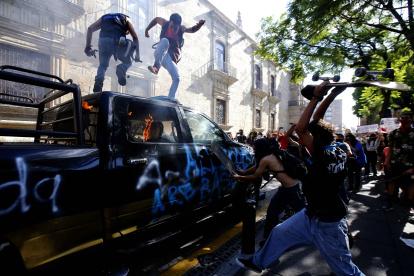 GUADALAJARA. Un grupo de personas atacan a varios vehículos estacionados en una avenida de esta ciudad mexicana la tarde y noche de este jueves.