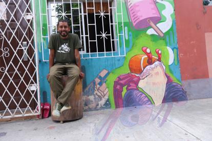 Gabriel Peña, muralista guayaquileño, posando en una de sus pinturas en su sector.