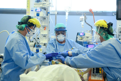 Member of the medical staff take care of a patient infected by the novel coronavirus, at the COVID-19 division at the ASST Papa Giovanni XXIII hospital in Bergamo, on April 3, 2020. Italy"s three-week lockdown to stop the spread of COVID-19 has been extended through at least mid-April and its economy is expected to suffer its biggest peacetime shock since World War II. / AFP / Piero CRUCIATTI

 ITALY-VIRUS-HEALTH