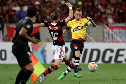 Filipe Luis (i) de Flamengo disputa el balón con Damian Díaz de Barcelona en uno de los últimos partidos de la Copa Libertadores disputados en marzo pasado.