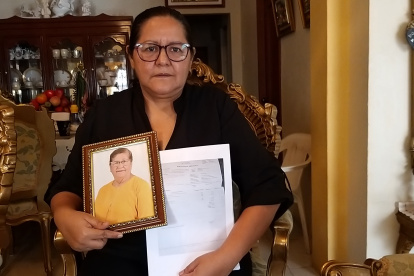 Elsa Maldonado sostiene un retrato de su madre y los papeles de defunción.