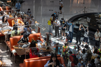HONG KONG. Manifestantes en favor de la democracia participan este martes en una manifestación en un centro comercial.
