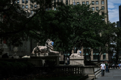 NUEVA YORK.Las estatuas de leones de mármol en la entrada de la Biblioteca Pública de la Gran Manzana, están adornadas con máscaras.