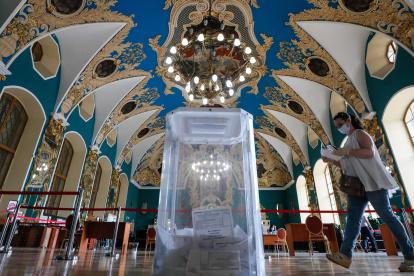 MOSCÚ. Un votante,con máscara facial y guantes, camina hacia una urna para emitir su voto en un colegio electoral de la estación de ferrocarril de Kazansky.