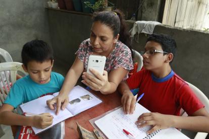 En la cooperativa Sergio Toral, del noroeste de Guayaquil, Melba Alvarado comparte su teléfono entre sus tres hijos para que estos se conecten con sus maestros.