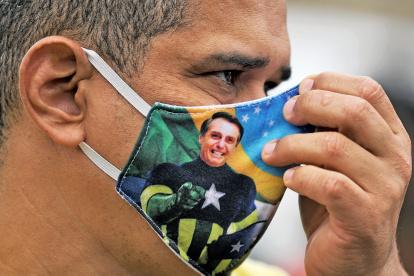 Un seguidor de Bolsonaro porta una mascarilla en la que el rostro del presidente de Brasil aparece con el cuerpo del personaje "Capitán América".