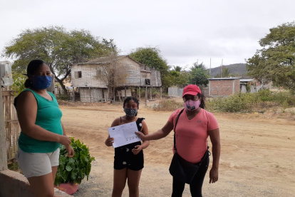 La profesora Rocío Ureta entrega las fichas pedagógicas a uno de sus alumnos en la zona rural de Sucre, Manabí.