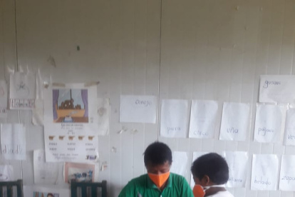 Aprovechando la visita a la escuela Misael Nastacua para la entrega de fichas impresas, el profesor Juan Herrera absuelve las dudas de un alumno.