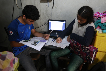 En la cooperativa de vivienda Sergio Toral, del noroeste de Guayaquil, dos hermanos comparten una computadora para sus clases.