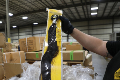 This handout photograph obtained July 1, 2020 courtesy of US Customs and Border Protection Office of Public Affairs and taken on June 29, 2020 shows Officers of Customs and Border Protection (CBP) Office of Field Operations (OFO) at the Port of New York/Newark inspecting a shipment of hair pieces and accessories from China, part of which is suspected to have been made with forced or prison labor in violation of US Law. - US customs officials said July 1, 2020 that they had seized a shipment of human hair products from China believed to be produced by Muslims held in labor camps in the country"s western Xinjiang province. (Photo by Handout / US Customs and Border Protection / AFP) / RESTRICTED TO EDITORIAL USE - MANDATORY CREDIT "AFP PHOTO /US Customs and Border Protection Office of Public Affairs " - NO MARKETING - NO ADVERTISING CAMPAIGNS - DISTRIBUTED AS A SERVICE TO CLIENTS
