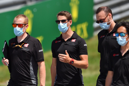 Algunos integrantes del equipo Haas, con el piloto francés Romain Grosjean (c), con las protecciones del caso en el circuito de Austria.
