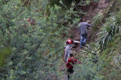 Foto del 13 de mayo que muestra a migrantes venezolanos que bajan por un desfiladero cerca de la frontera de Ecuador con Colombia, poco antes de cruzar el río Carchi.