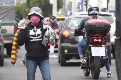 Vendedores ambulantes en Quito utilizan insumos de bioseguridad durante su jornada.