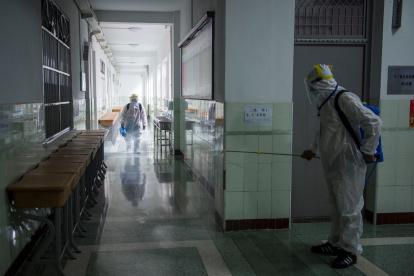 WUHAN. Personal sanitarios desinfectan un área de una escuela antes del Examen de ingreso a la universidad nacional (NCEE), conocido como Gaokao.