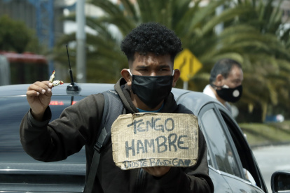 Un hombre vende dulces y pide ayuda en un semáforo en Bogotá (Colombia). EFE/Mauricio Duenas Castañeda