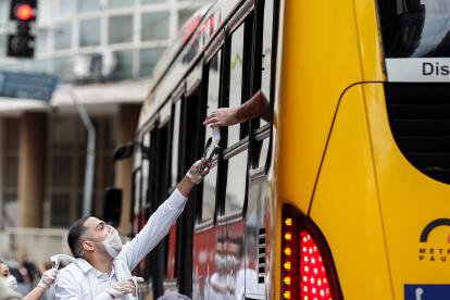 Voluntarios entregan, el pasado miércoles 01 de julio del 2020, mascarillas durante una operación de Vigilancia Sanitaria para fiscalizar y advertir sobre el uso obligatorio para prevenir el contagio del COVID-19, en el centro de Sao Paulo (Brasil). EFE/Sebastiao Moreira