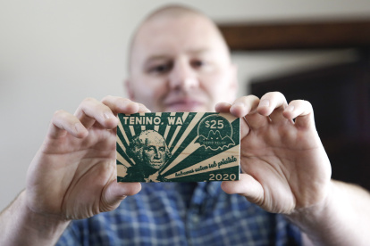 Mayor Wayne Fournier holds $25 in wooden money, in Tenino, Washington on July 10, 2020. - Tenino had become a ghost town, and small businesses were struggling to survive amid the coronavirus pandemic, so local officials revived an unconventional idea from the last century: print its own currency on planks of wood. (Photo by Jason Redmond / AFP)