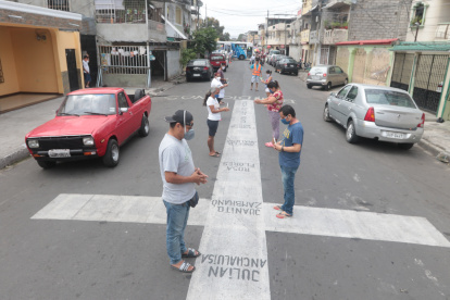 Los vecinos del suburbio rezan alrededor de las cruces, por los fallecidos por COVID-19