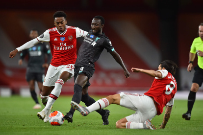 Naby Keita es marcado por Dani Ceballos (derecha) Joe Willock (izquierda) durante el partido de esta tarde en el Emirates Stadium, de Londres.